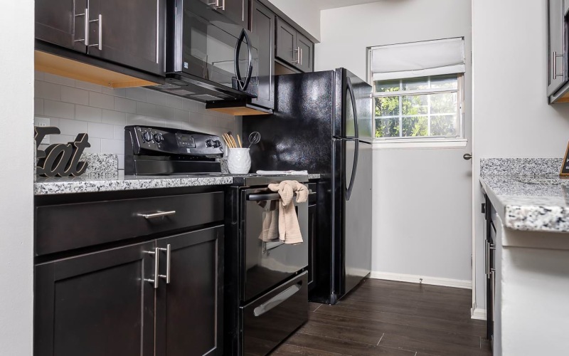 Kitchen with brown cabinets and black appliances