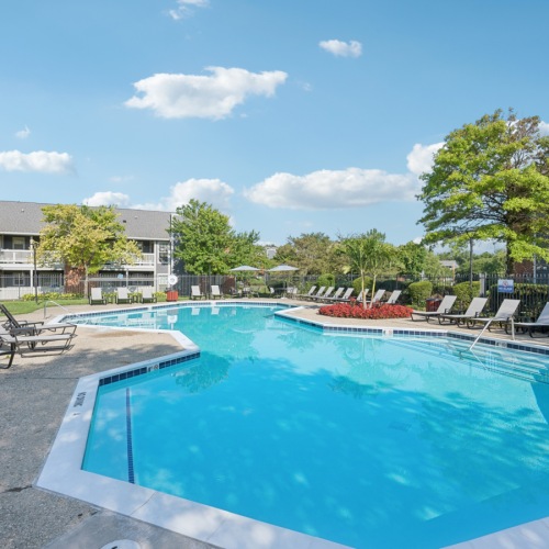 a swimming pool with a clubhouse behind it