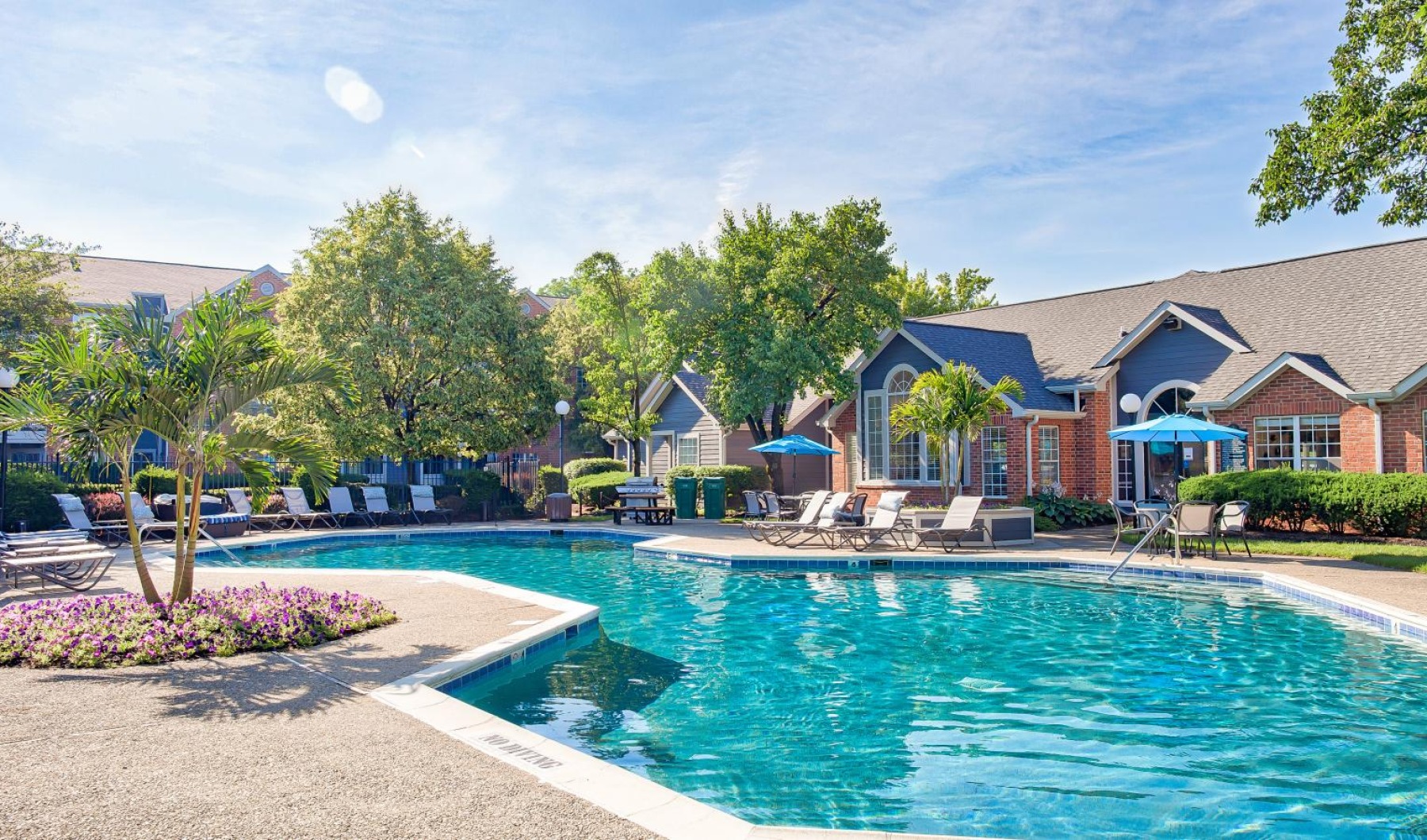 Sparkling swimming pool a swimming pool with a clubhouse behind it