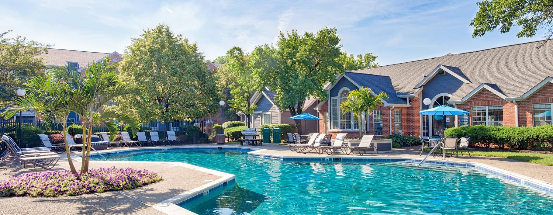 a swimming pool with a clubhouse behind it